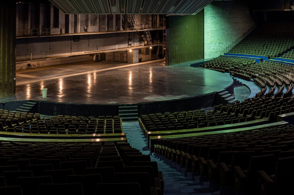 O sală de teatru mare, privită dinspre rândurile de sus către scenă